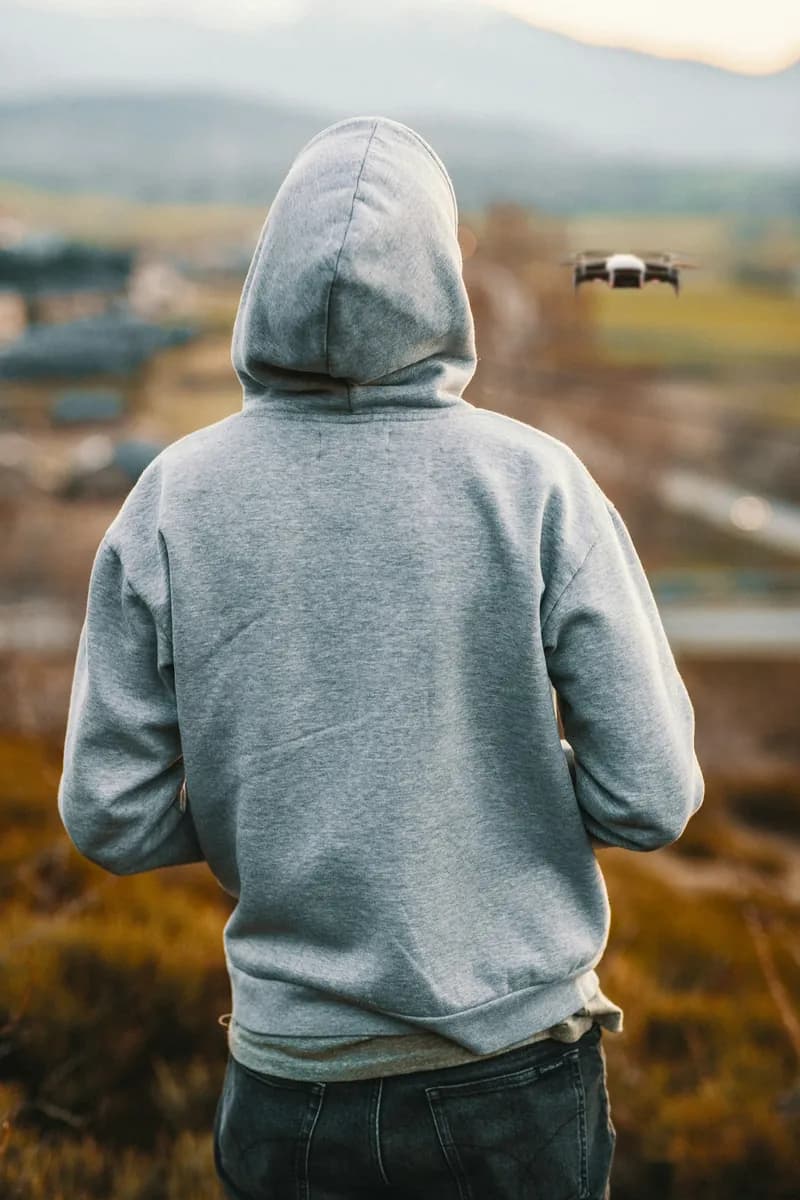Heavyweight grey hoodie folded on a wooden bench in soft natural light