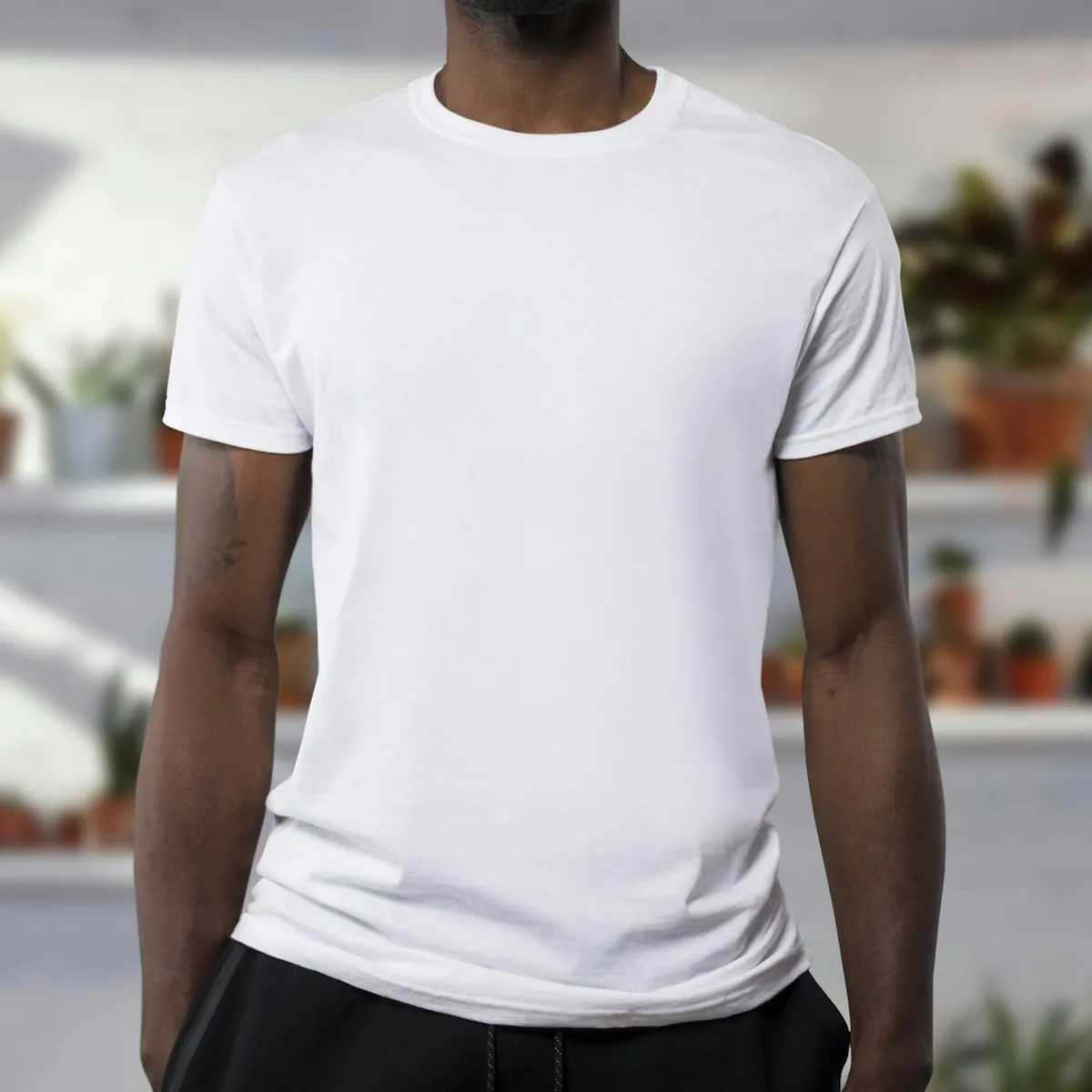 Folded cotton t-shirts in neutral tones on a clean shelf